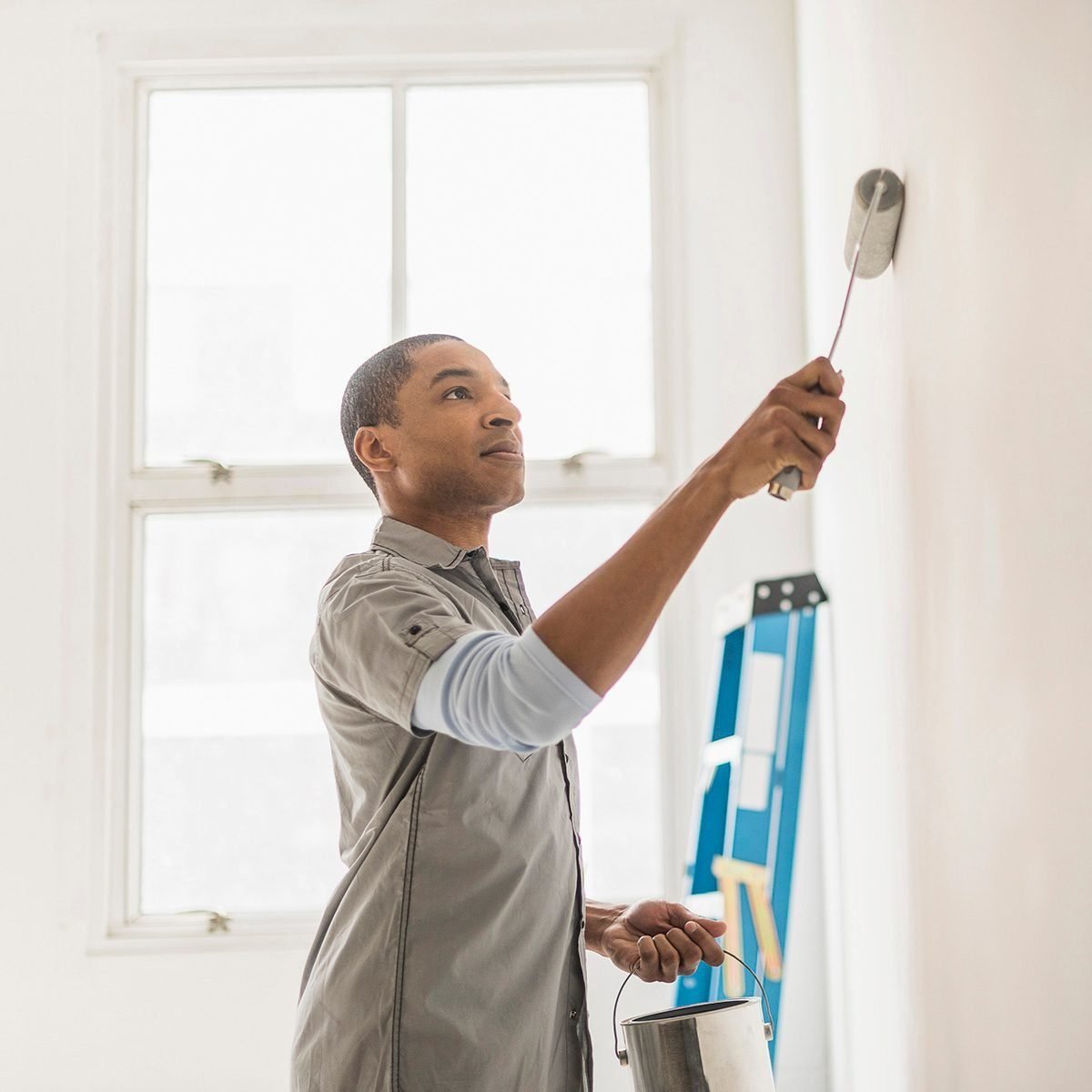 black man painting wall of home 565974977